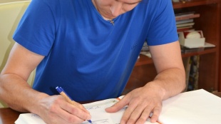 Martin Hyška pri podpise do pamätnej knihy