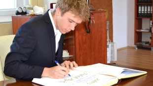 Patrik Megela pri podpise do pamätnej knihy